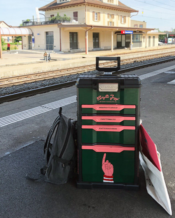 Schriftenmalerin unterwegs mit Velo und Veloanhänger und Öffentlichen Verkehrsmitteln